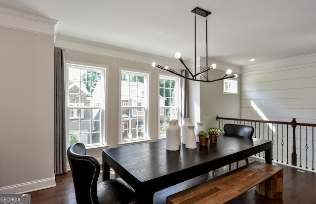 dining area with dark hardwood / wood-style floors, an inviting chandelier, a wealth of natural light, and crown molding