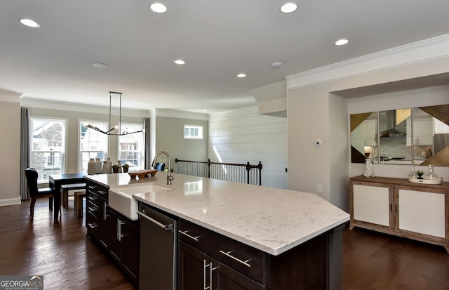 kitchen with sink, hanging light fixtures, stainless steel dishwasher, an island with sink, and ornamental molding