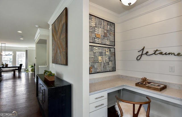 office area with dark hardwood / wood-style floors, built in desk, and crown molding