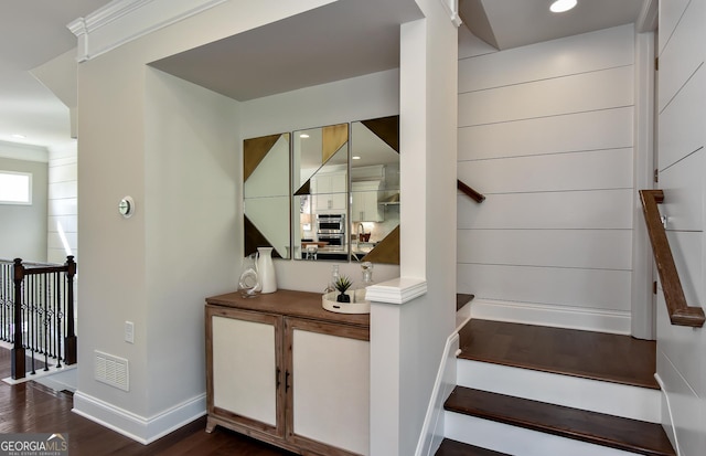 bar featuring dark hardwood / wood-style floors, stainless steel oven, and white cabinetry