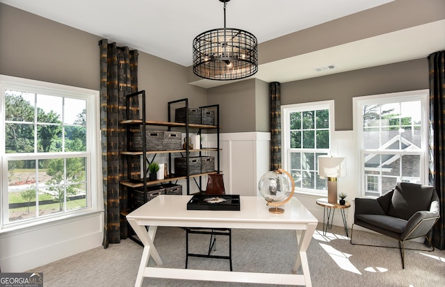 carpeted office space with an inviting chandelier and a wealth of natural light