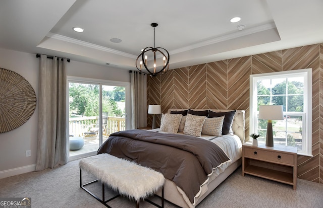 carpeted bedroom featuring a tray ceiling, access to exterior, and ornamental molding