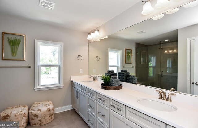 bathroom featuring tile patterned flooring, vanity, and a shower with shower door