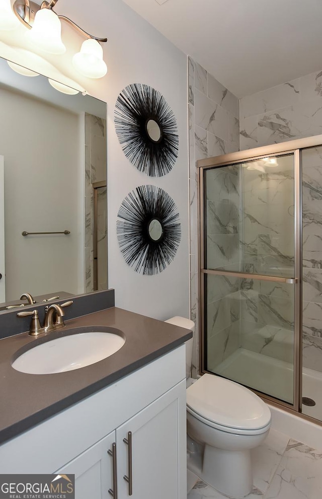 bathroom with vanity, toilet, and a shower with shower door