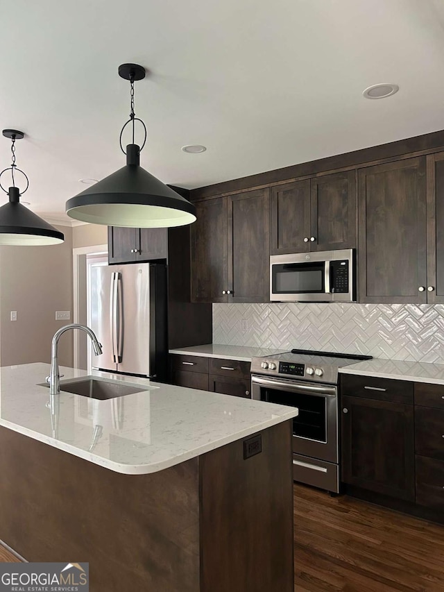 kitchen featuring backsplash, pendant lighting, sink, and stainless steel appliances