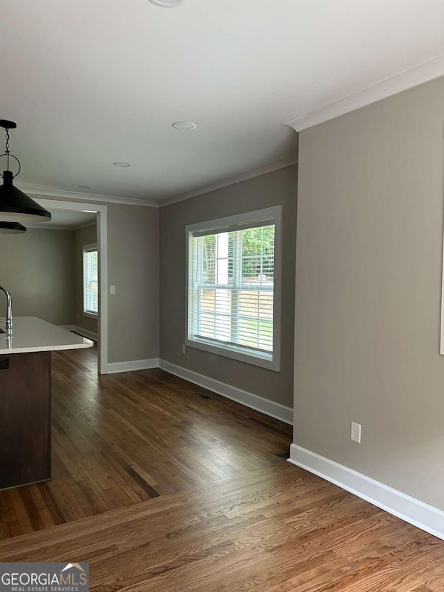 unfurnished living room featuring ornamental molding and a wealth of natural light