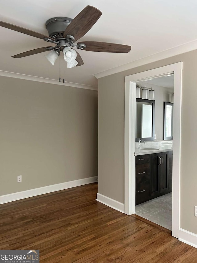 unfurnished room with crown molding, ceiling fan, sink, and wood-type flooring