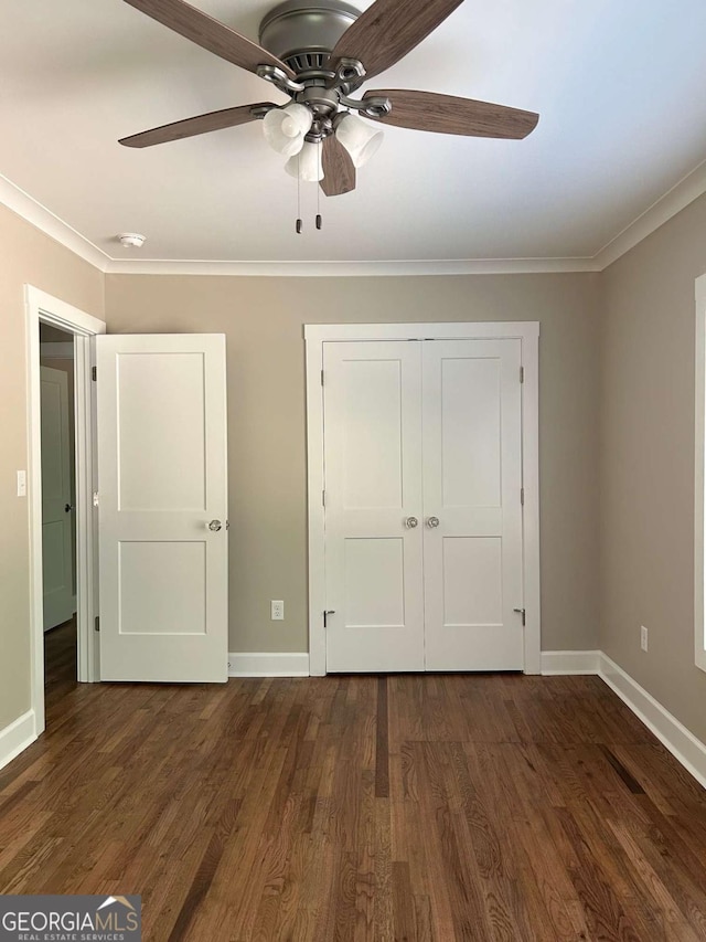 unfurnished bedroom featuring ceiling fan, dark hardwood / wood-style floors, ornamental molding, and a closet