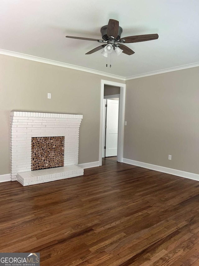 unfurnished living room with dark hardwood / wood-style floors, a brick fireplace, ceiling fan, and ornamental molding