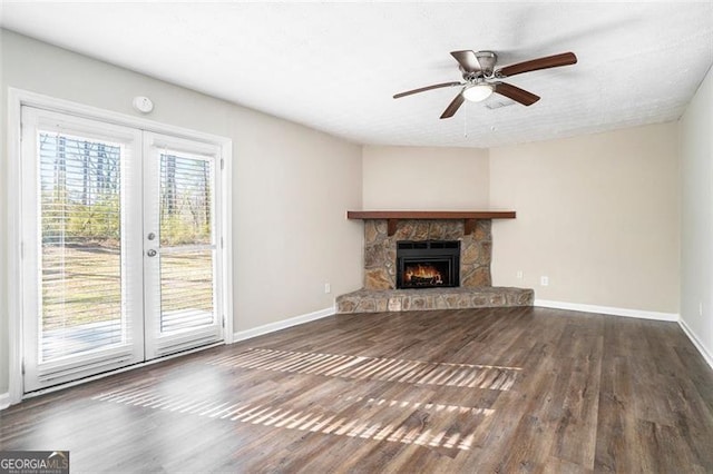 unfurnished living room with a fireplace, french doors, dark hardwood / wood-style floors, and ceiling fan