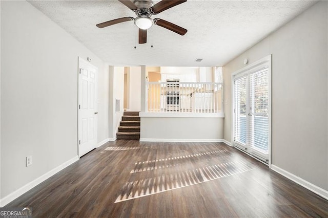 unfurnished living room featuring a textured ceiling, dark hardwood / wood-style floors, and ceiling fan