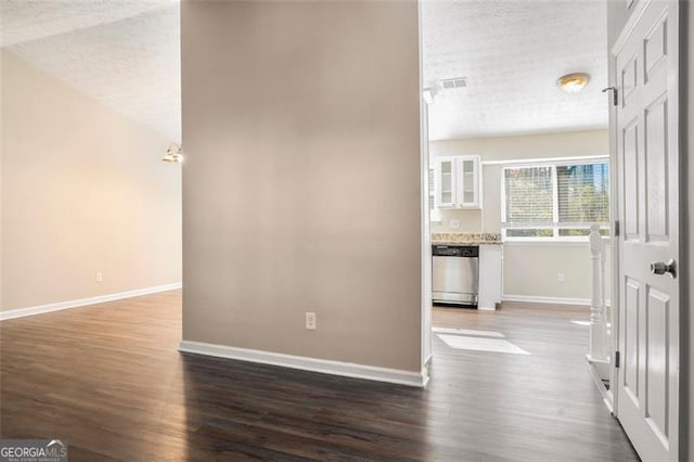 interior space with a textured ceiling, wood-type flooring, and lofted ceiling