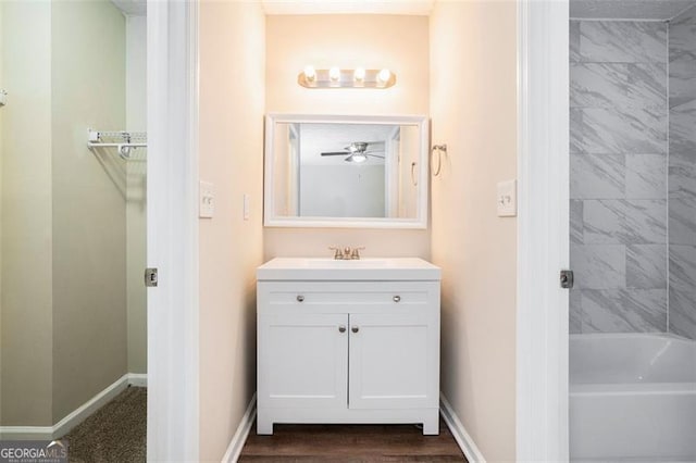 bathroom featuring ceiling fan, vanity, and tiled shower / bath