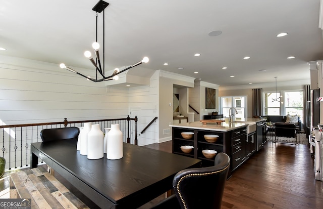 dining area with sink, ornamental molding, and dark wood-type flooring