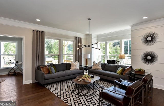 living room with dark hardwood / wood-style flooring, a chandelier, and ornamental molding