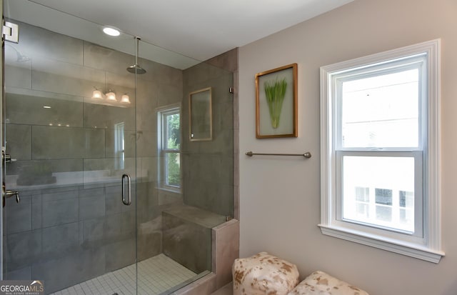 bathroom with a shower with door and plenty of natural light