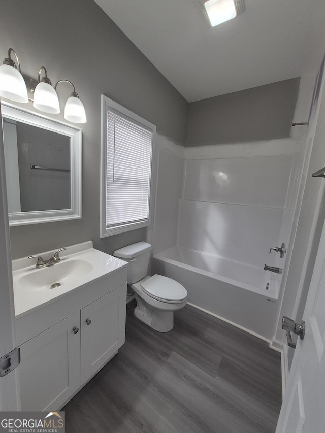 full bathroom featuring toilet, vanity,  shower combination, and hardwood / wood-style flooring