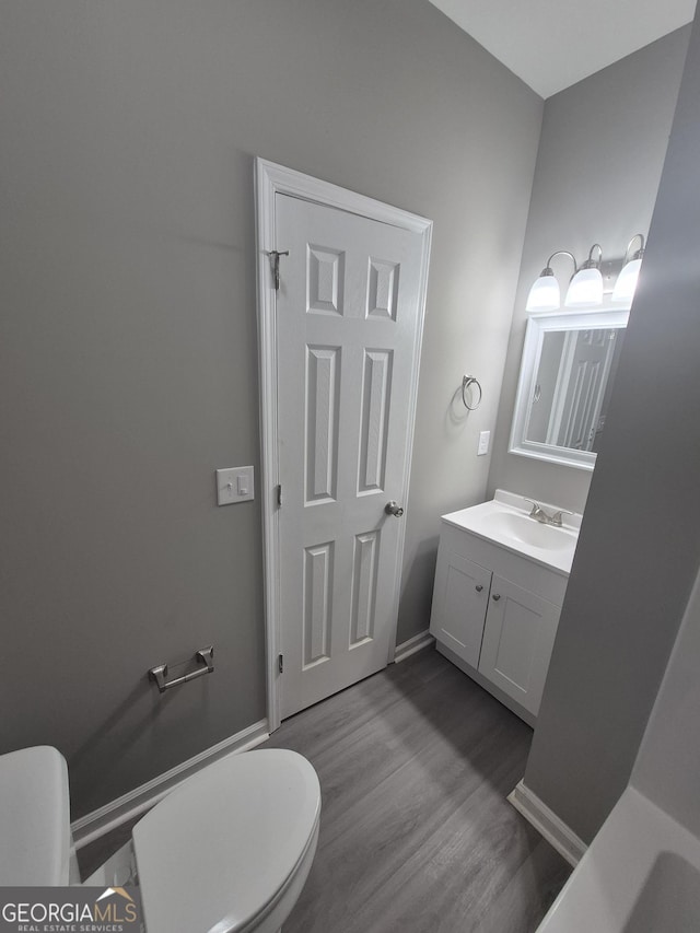 bathroom with vanity, toilet, and wood-type flooring