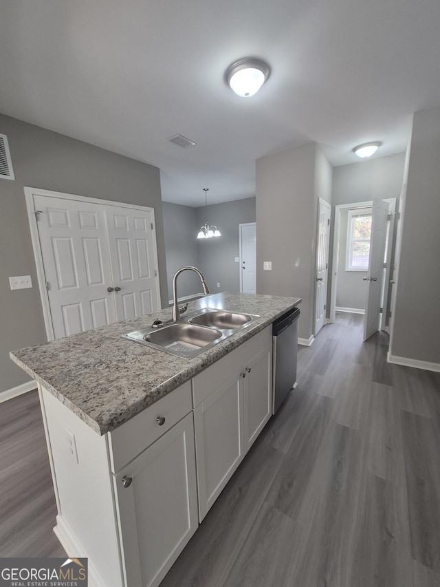 kitchen featuring a kitchen island with sink, sink, pendant lighting, dishwasher, and white cabinets