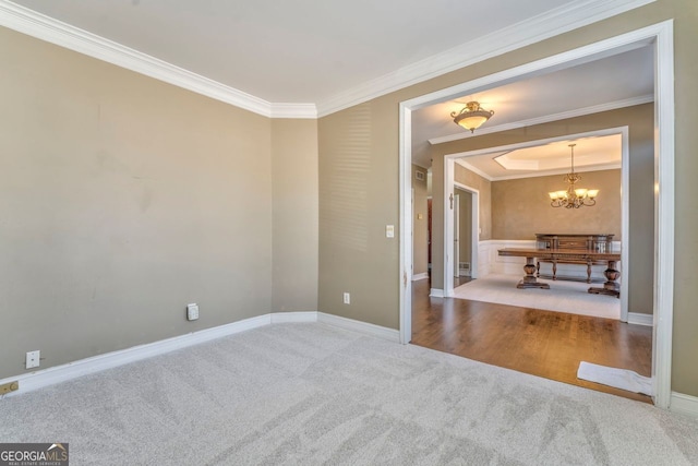 unfurnished room featuring carpet flooring, crown molding, and a chandelier