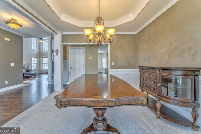 dining room with a tray ceiling, crown molding, a chandelier, and dark hardwood / wood-style floors