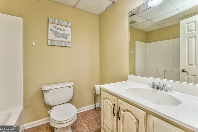 full bathroom featuring a paneled ceiling, tile patterned flooring, toilet, and vanity