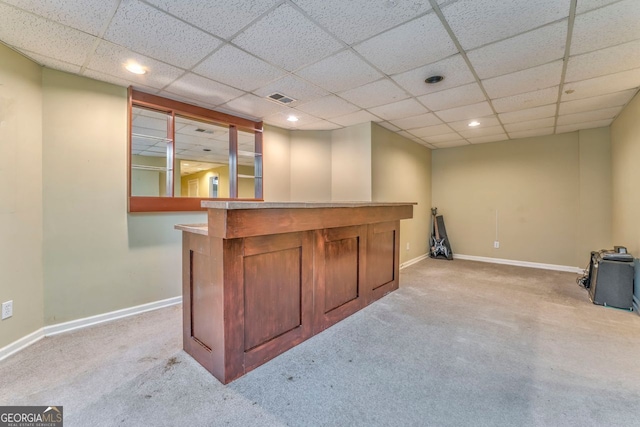 bar featuring a paneled ceiling and light carpet