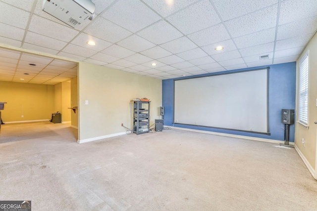 carpeted cinema room with a drop ceiling