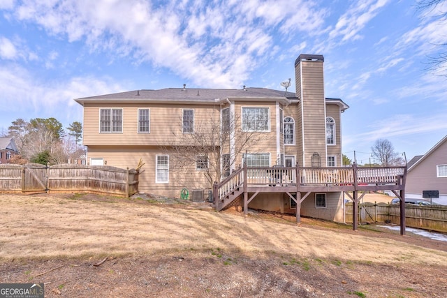 rear view of property featuring a yard, central AC unit, and a wooden deck