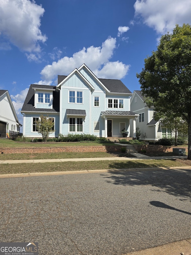 view of front facade featuring a standing seam roof, metal roof, and board and batten siding