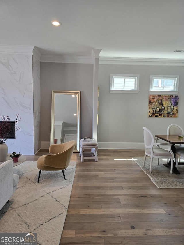 living room with baseboards, visible vents, ornamental molding, and wood finished floors