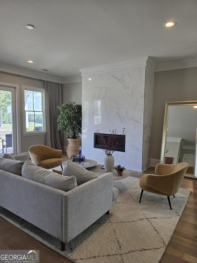 living area with recessed lighting, wood finished floors, a high end fireplace, and crown molding