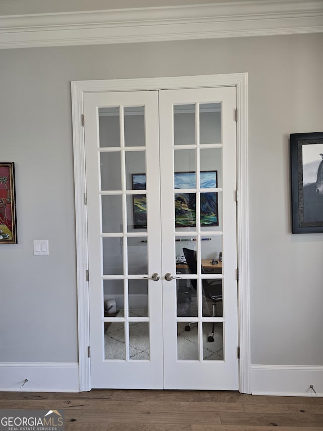 entryway with baseboards, wood finished floors, crown molding, and french doors