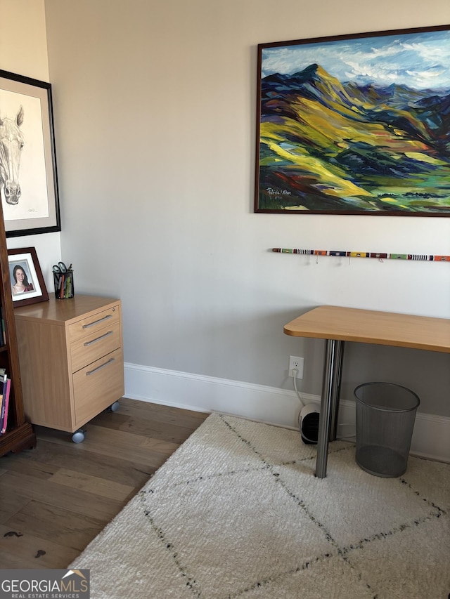 interior space with baseboards and wood finished floors