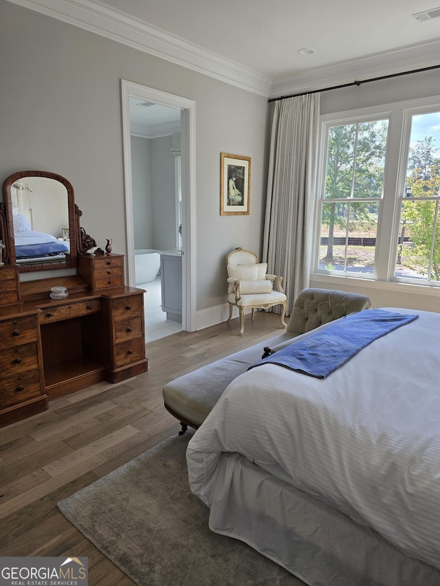 bedroom featuring baseboards, visible vents, crown molding, and wood finished floors