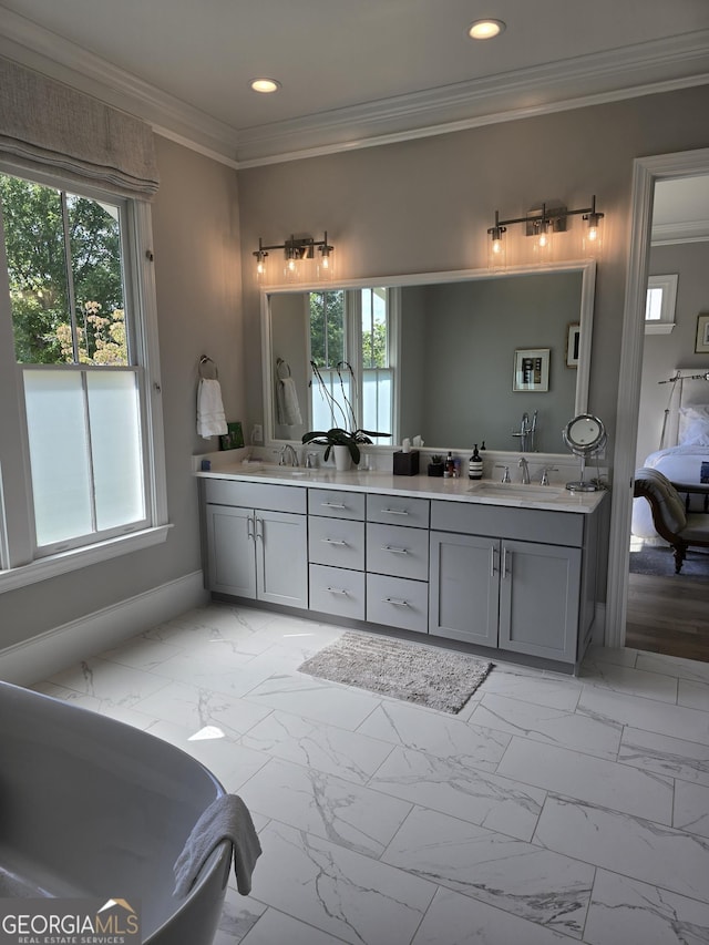 bathroom featuring ornamental molding, marble finish floor, double vanity, and a healthy amount of sunlight