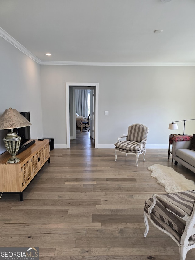 living area with crown molding, baseboards, wood finished floors, and recessed lighting