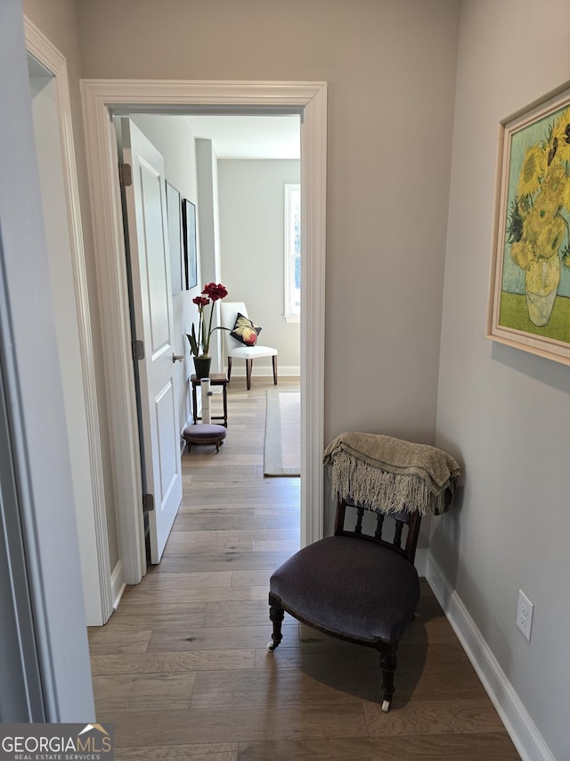 hallway featuring wood finished floors and baseboards