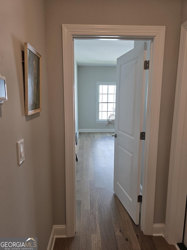 hallway with baseboards and wood finished floors