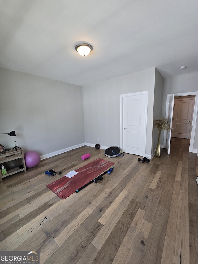 workout room with baseboards and wood finished floors