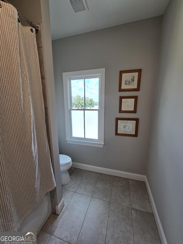 bathroom featuring curtained shower, baseboards, visible vents, and toilet