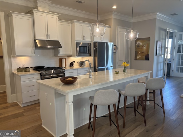 kitchen featuring appliances with stainless steel finishes, dark wood-type flooring, white cabinetry, and under cabinet range hood