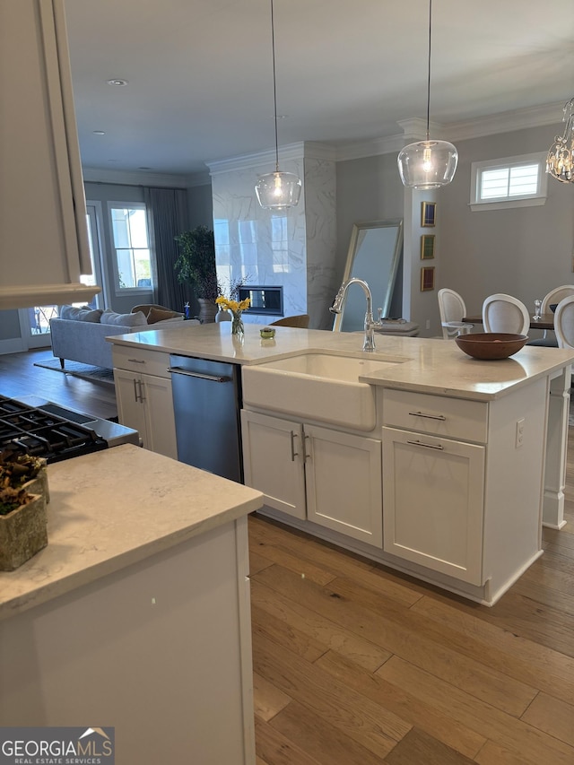 kitchen with a sink, dishwashing machine, white cabinetry, and crown molding