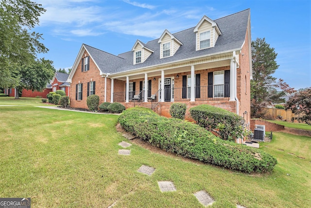 cape cod house with a front yard, a porch, and cooling unit