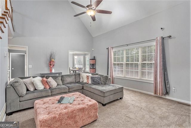 living room featuring ceiling fan, high vaulted ceiling, and light carpet