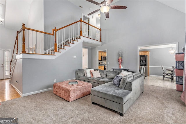 carpeted living room featuring ceiling fan and high vaulted ceiling