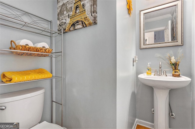 bathroom featuring crown molding and toilet