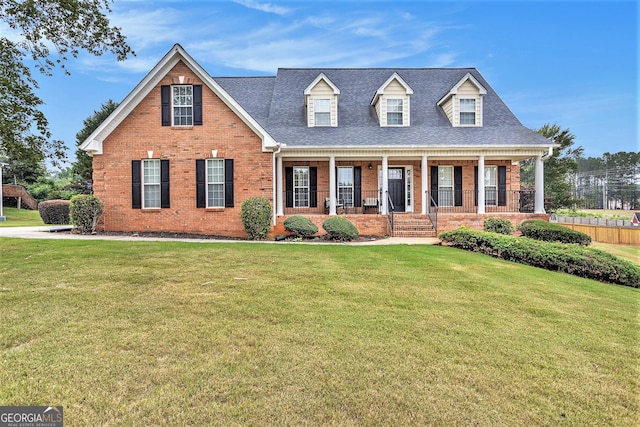 new england style home featuring covered porch and a front lawn