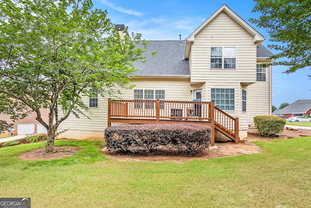 rear view of house featuring a yard and a wooden deck