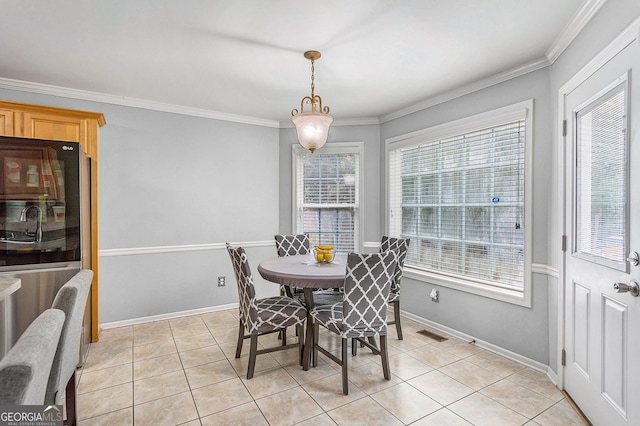 dining space with crown molding, a healthy amount of sunlight, and light tile patterned flooring